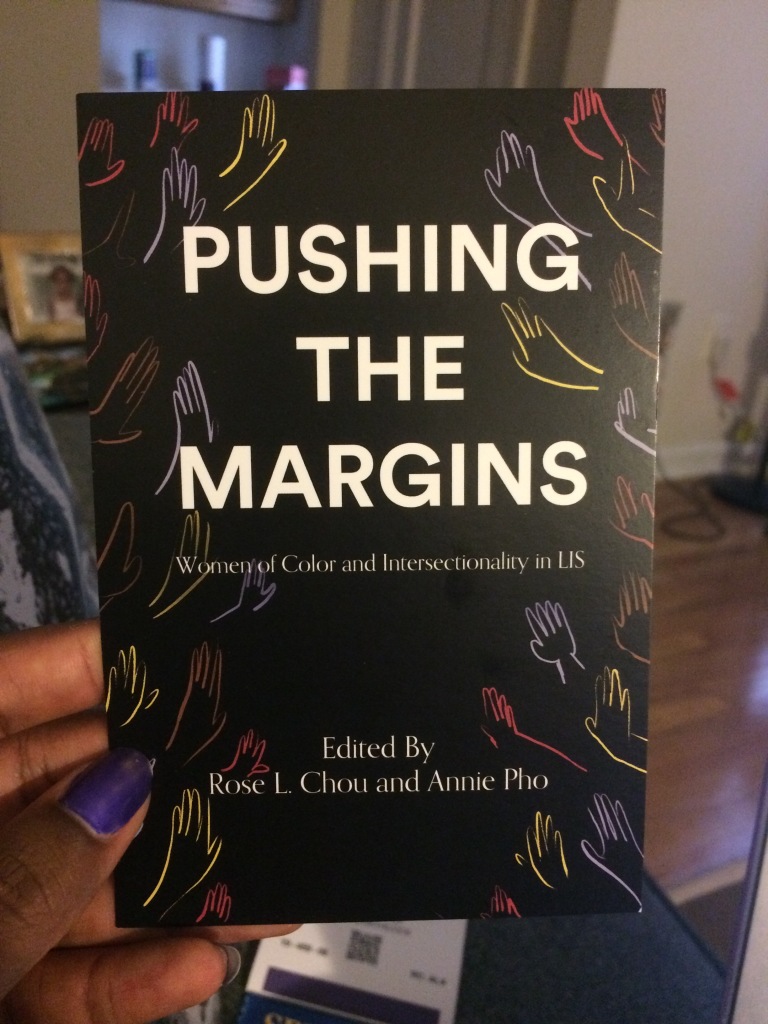 black postcard with multicolored hand outlines in background titled "Pushing the Margins: Women of Color and Intersectionality in LIS," edited by Rose L. Chou and Annie Pho